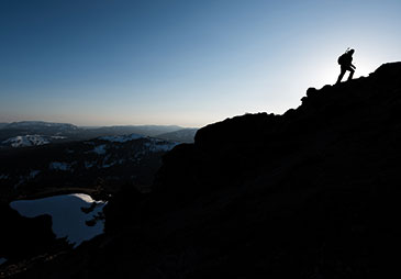 A man walking on a ridge at sundown